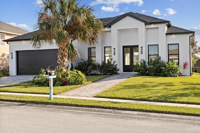 view of front facade with a garage, french doors, and a front lawn