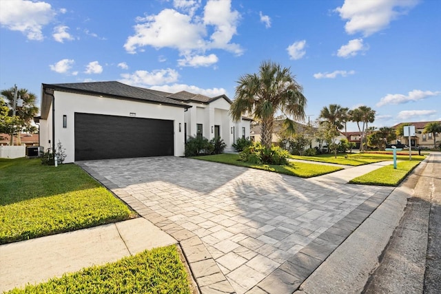 view of front of home with cooling unit, a front yard, and a garage