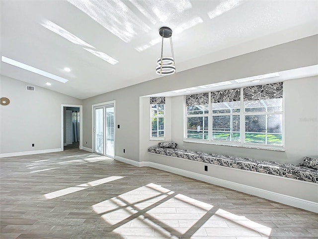 interior space featuring lofted ceiling with skylight