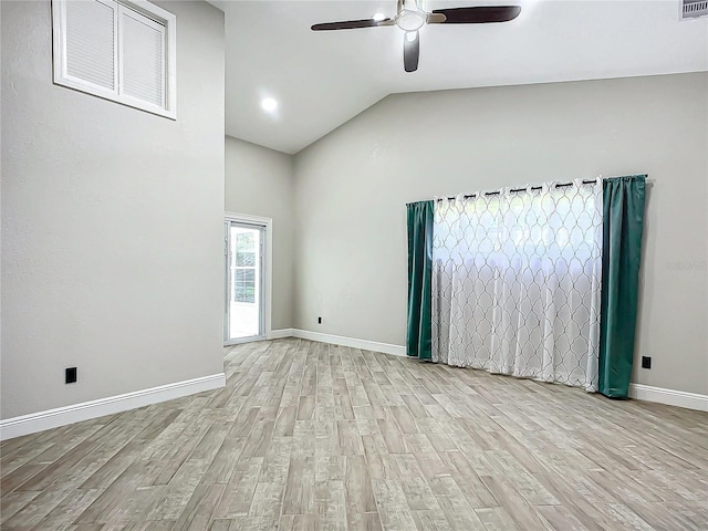 empty room with ceiling fan, vaulted ceiling, and light hardwood / wood-style flooring