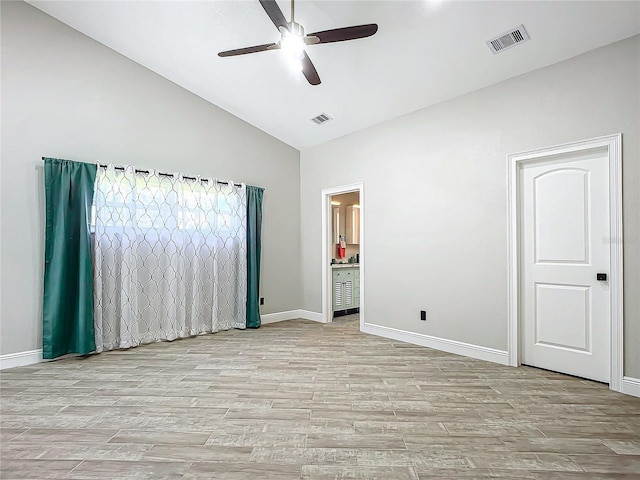 unfurnished bedroom with ceiling fan, light hardwood / wood-style flooring, connected bathroom, and high vaulted ceiling