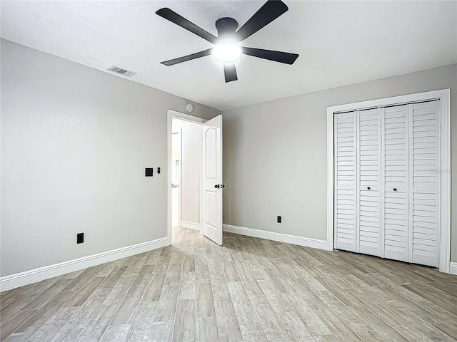 unfurnished bedroom featuring ceiling fan, light hardwood / wood-style floors, and a closet