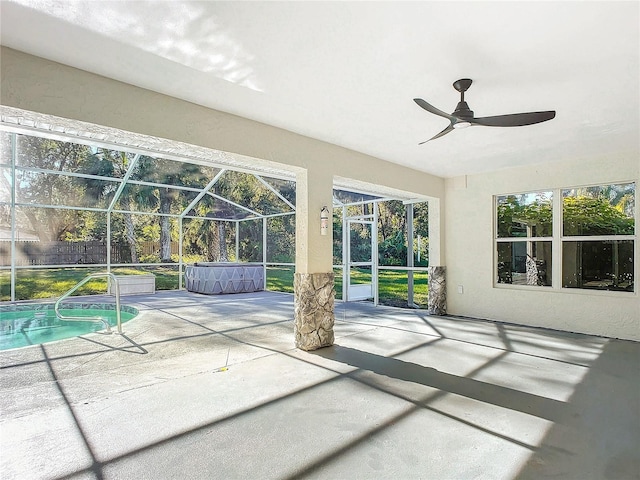 unfurnished sunroom featuring ceiling fan and a pool