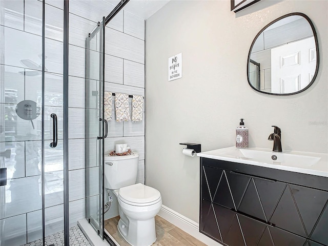 bathroom featuring toilet, an enclosed shower, hardwood / wood-style floors, and vanity