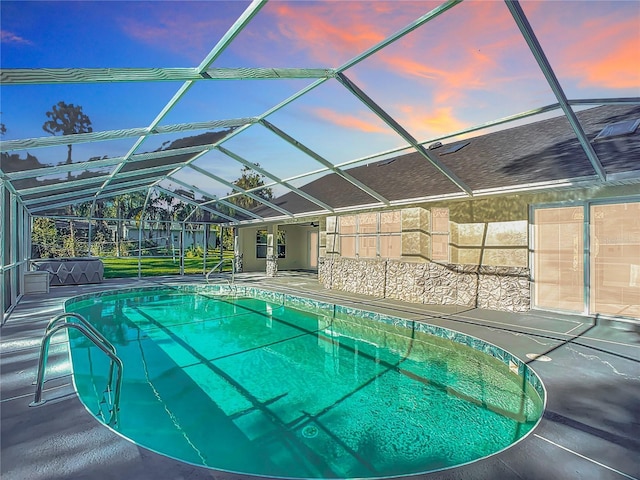 pool at dusk with a patio area and glass enclosure