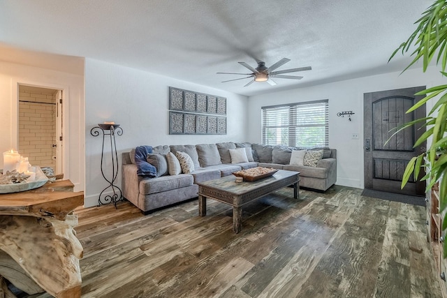 living room with a textured ceiling, dark hardwood / wood-style floors, and ceiling fan