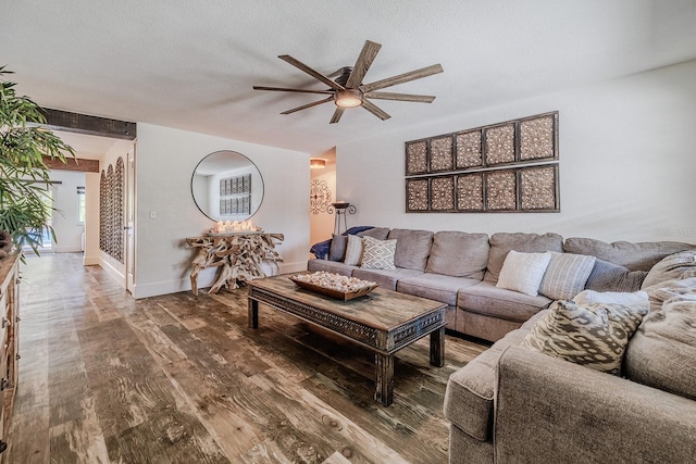 living room featuring hardwood / wood-style flooring, ceiling fan, and a textured ceiling