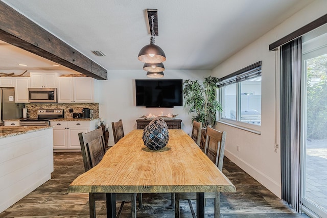 dining area featuring beamed ceiling and dark wood-type flooring