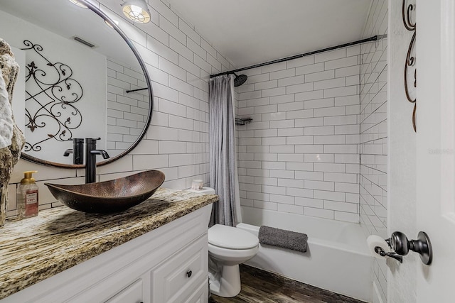 full bathroom with shower / bathtub combination with curtain, wood-type flooring, vanity, tile walls, and toilet