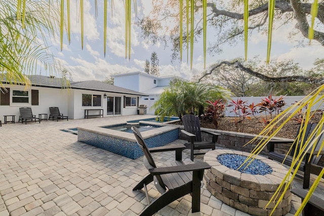 view of patio featuring a pool with hot tub and an outdoor fire pit