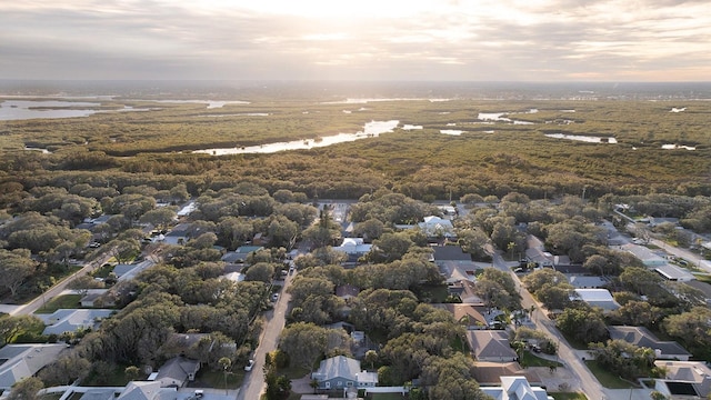 aerial view at dusk featuring a water view