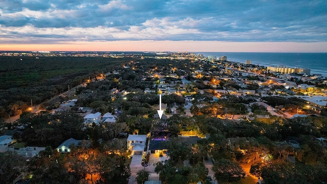 aerial view at dusk featuring a water view