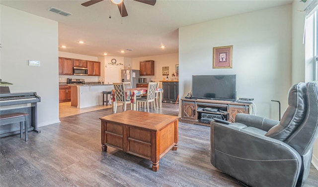 living room featuring ceiling fan and dark wood-type flooring