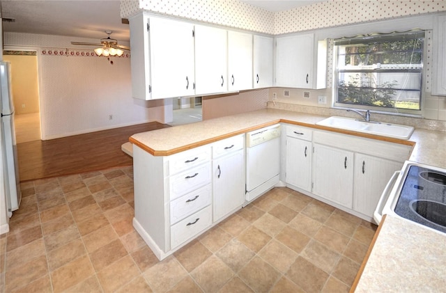 kitchen featuring kitchen peninsula, white appliances, ceiling fan, sink, and white cabinets