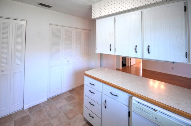 kitchen with white dishwasher and white cabinetry