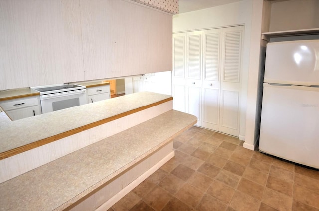 kitchen featuring white cabinetry and white appliances