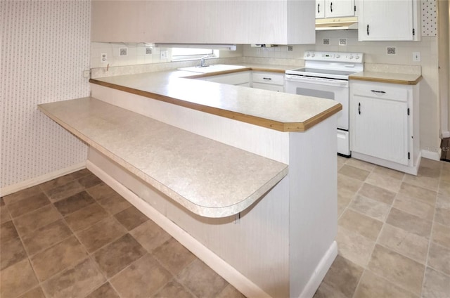 kitchen featuring white cabinets, sink, electric range, kitchen peninsula, and a breakfast bar area