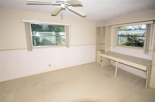 interior space featuring ceiling fan, light carpet, and a textured ceiling