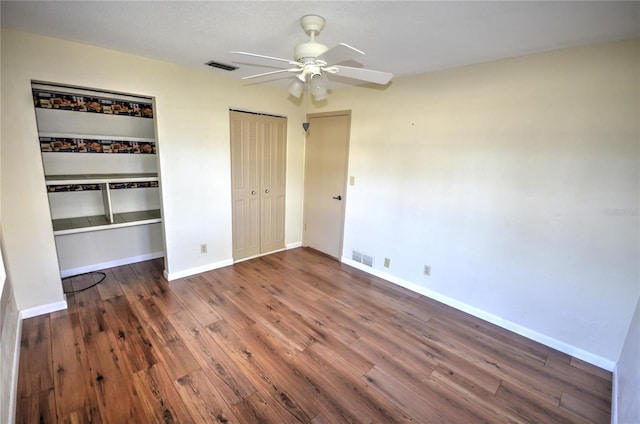 unfurnished bedroom featuring ceiling fan and dark hardwood / wood-style floors