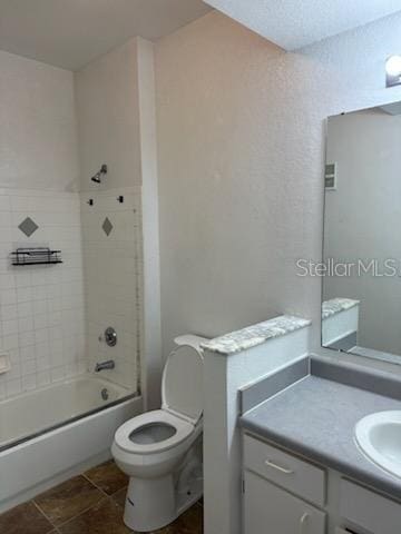 full bathroom with toilet, vanity, and tiled shower / bath