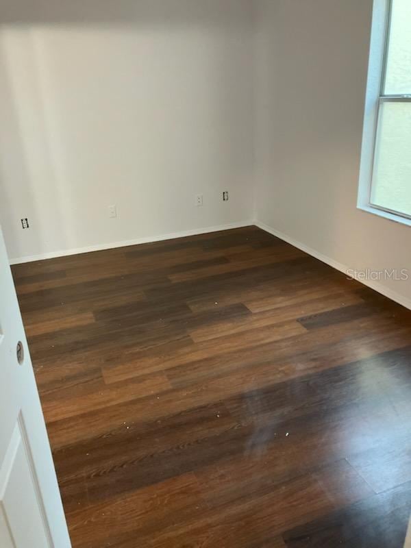 empty room with dark wood-type flooring