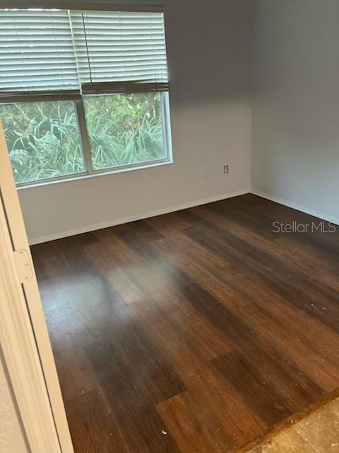 unfurnished room featuring dark hardwood / wood-style flooring