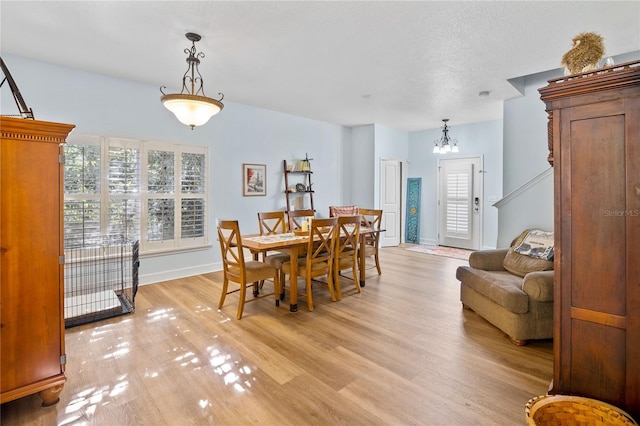 dining space with a notable chandelier and light wood-type flooring