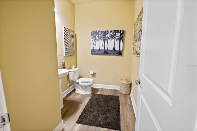 bathroom with hardwood / wood-style floors and toilet