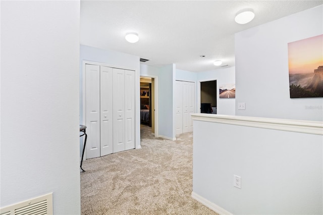 corridor with light colored carpet