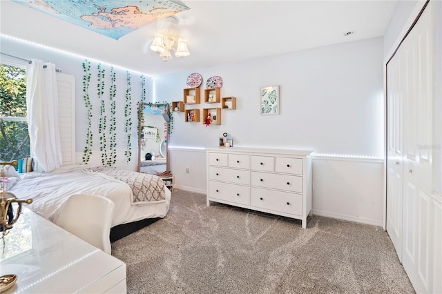 bedroom featuring light colored carpet, a closet, and a notable chandelier