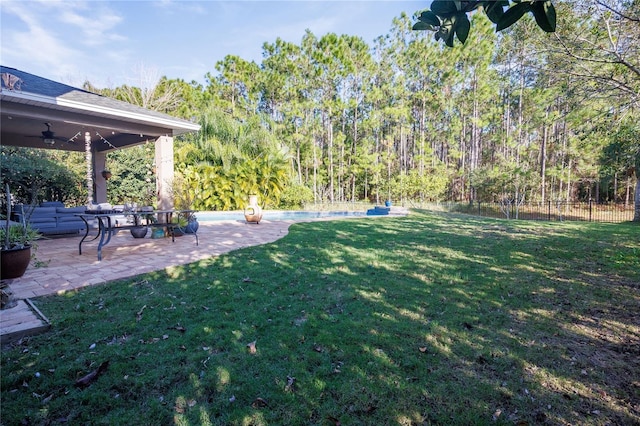 view of yard with ceiling fan and a patio area