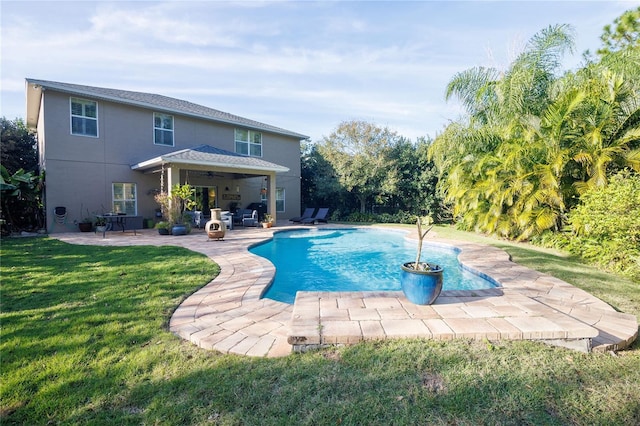 view of pool featuring ceiling fan, a patio area, and a lawn