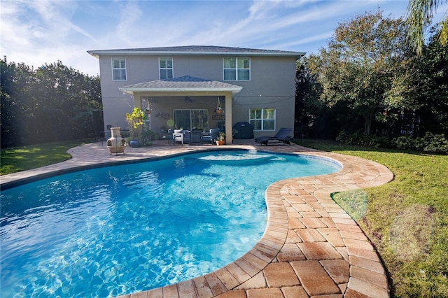 view of pool featuring a patio, ceiling fan, a grill, and a lawn