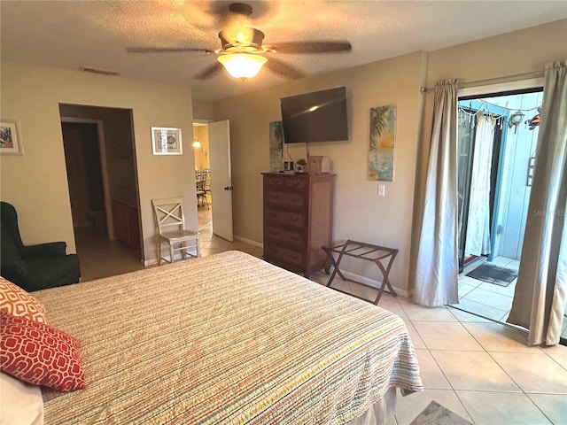 bedroom featuring ceiling fan, light tile patterned floors, a textured ceiling, and connected bathroom