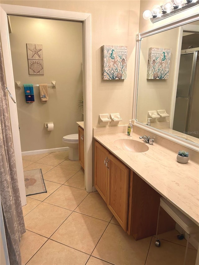 bathroom with tile patterned floors, a shower, vanity, and toilet