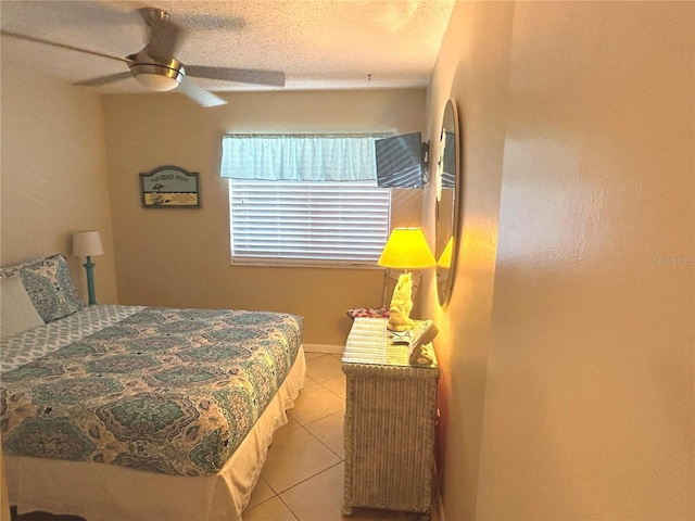 tiled bedroom featuring a textured ceiling and ceiling fan