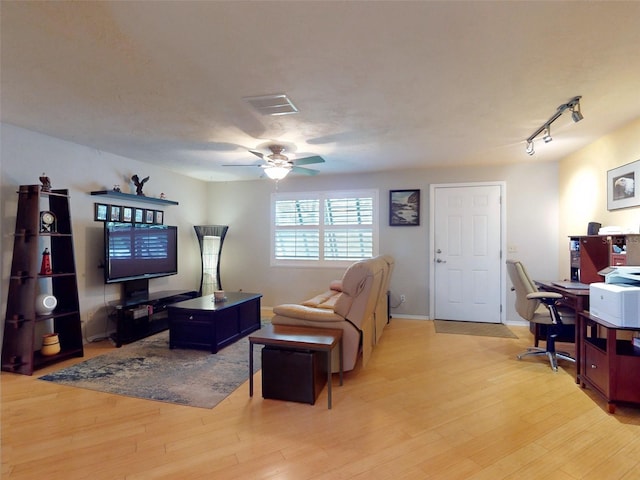 living room with ceiling fan, rail lighting, and light hardwood / wood-style flooring