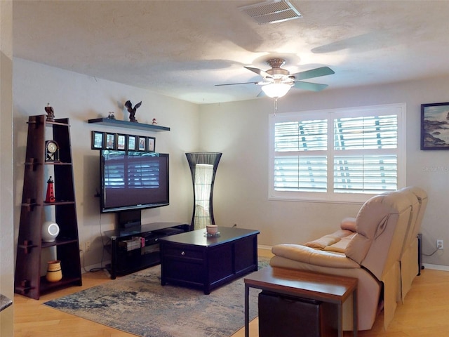 living room with ceiling fan and light hardwood / wood-style flooring