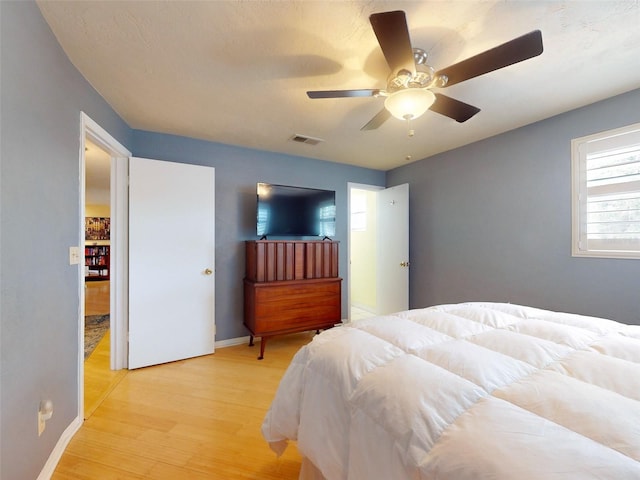 bedroom with ceiling fan and light hardwood / wood-style floors