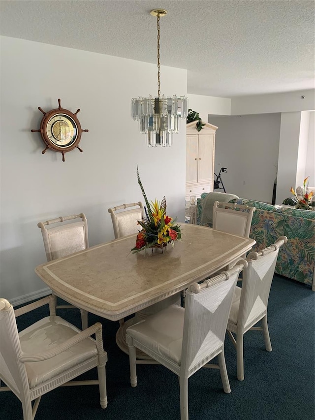 dining space featuring carpet, a chandelier, and a textured ceiling