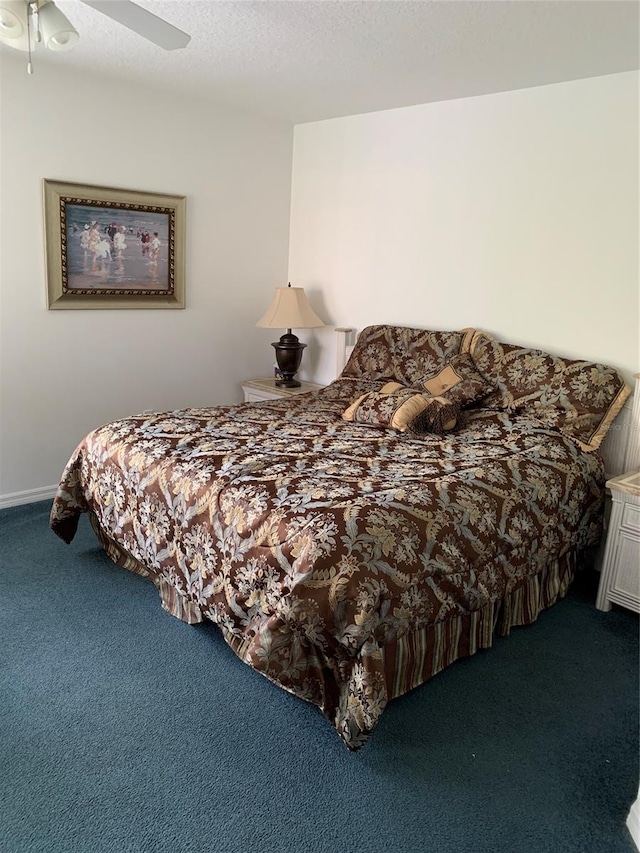 carpeted bedroom featuring a textured ceiling and ceiling fan