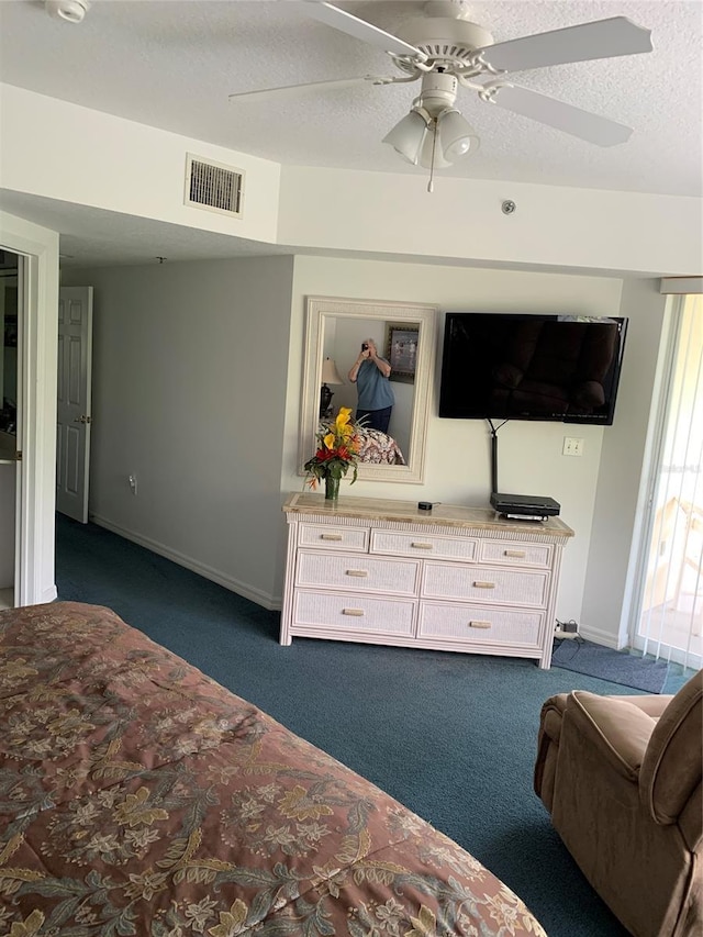 bedroom featuring ceiling fan, a textured ceiling, and dark colored carpet