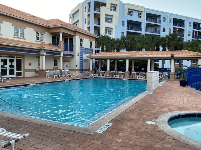 view of pool featuring a hot tub and a patio