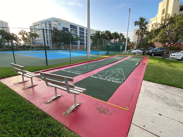 view of community featuring a lawn and tennis court