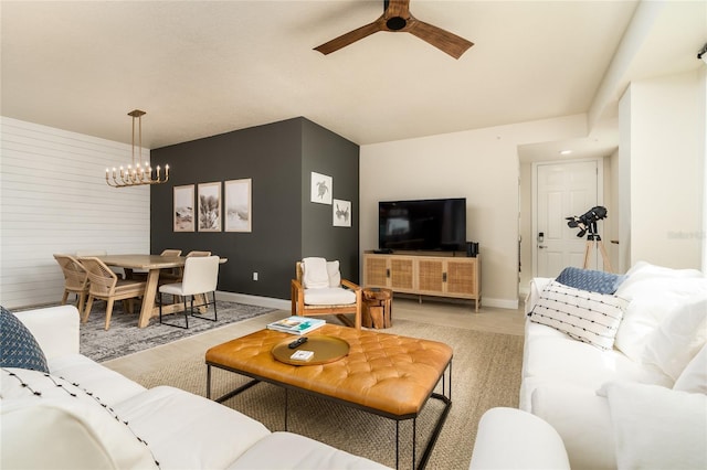 living room featuring ceiling fan with notable chandelier and hardwood / wood-style flooring