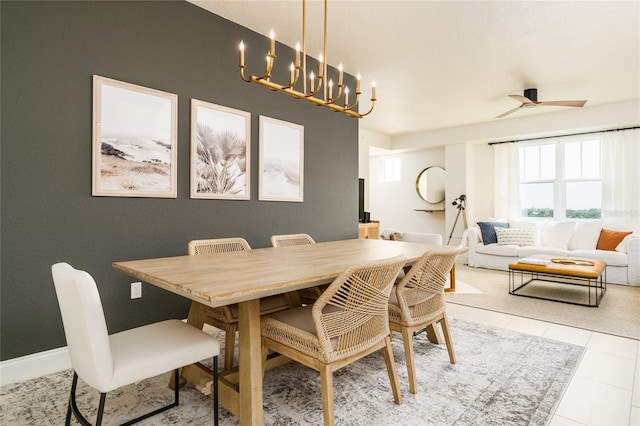 dining area with light tile patterned floors and ceiling fan with notable chandelier