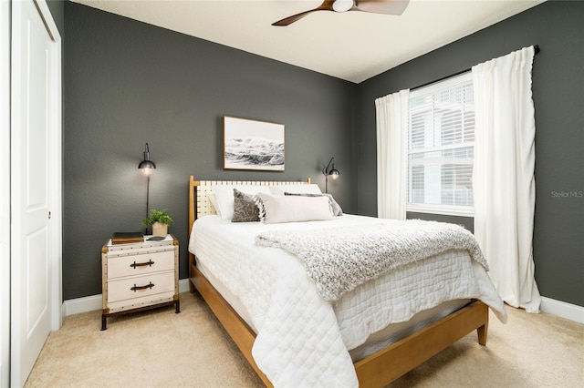 bedroom featuring ceiling fan, light carpet, and a closet