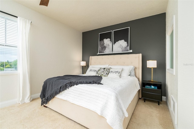 bedroom with ceiling fan and light carpet