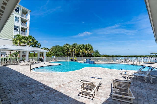 view of swimming pool with a water view and a patio