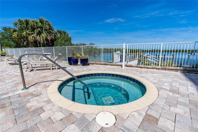 view of swimming pool featuring a patio area, an in ground hot tub, and a water view